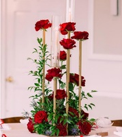 Pièce maîtresse de mariage élégante avec une combinaison d'arrangements floraux et de bougeoirs en métal antique pour la décoration