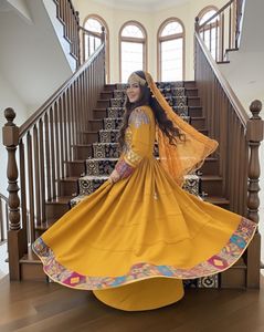 Belle femme afghane portant une robe traditionnelle jaune moutarde pashtun kuchi avec une broderie complexe et un couvre-chef matha patti - Product Image 3
