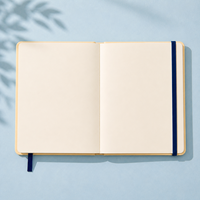 Carnet LABON personnalisé style méditerranéen, couverture rigide crème, bordure estampillée, vélo rouge vintage, scène côtière, feuille d'or, soleil, ruban bleu marine