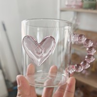 Taza de cristal transparente personalizable con lazo rosa y accesorio en forma de corazón con mango de cuentas
