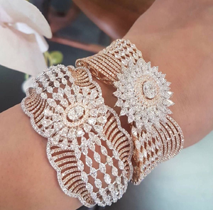 Par de brazaletes de latón de lujo con un motivo central de piedra en forma de rayos de sol y bandas onduladas. Disponible a precios de mayoreo. - Product Image 1