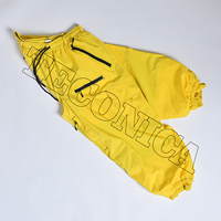 Pantalones de Nieve Amarillos de Alto Rendimiento con Ribete Negro, Forro Aislante Cálido, Múltiples Bolsillos con Cremallera y Cintura Ajustable con Cordón