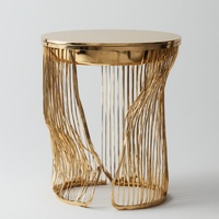 Table d'appoint moderne luxueuse avec dessus en métal véritable au design doré Base sculpturale unique Finition miroir pour le stockage
