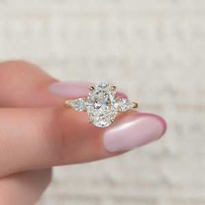 Anillo de compromiso de tres piedras CZ de corte ovalado de 7x9mm con piedras laterales de pera en oro | Joyería de propuesta nupcial - Product Image 1