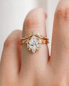 Conjunto de anillos de novia inspirado en la naturaleza con un impresionante anillo de diamante de corte pera cultivado en laboratorio y una banda curva de diseño único. - Product Image 1