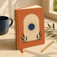 Carnet à spirale A5 personnalisé LABON, couverture en papier terre cuite, reliure spirale dorée, motif soleil, étoiles or et bleu marine, pages vierges, ruban