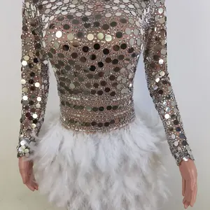 odysuit dress is covered in hundreds of small, round mirrors, giving it a dazzling, reflective effect. It covers the body from t