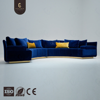 Canapé sectionnel incurvé de luxe sur mesure, alternative au dupe, avec tissu bleu riche et base dorée, options de revêtement personnalisées