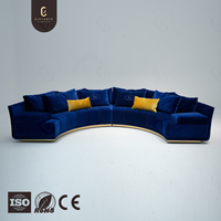 Canapé sectionnel incurvé de luxe sur mesure, alternative au dupe, avec tissu bleu riche et base dorée, options de revêtement personnalisées