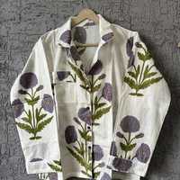 Ensemble de vêtements de détente élégants avec motifs de fleurs violettes et de feuilles vertes sur fond blanc, créant un design botanique frais.