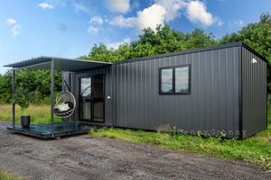 Maison préfabriquée en conteneur avec porte coulissante en verre, cabane modulaire extérieure en acier, cadre en aluminium noir, terrasse et chaise suspendue - Product Image 5