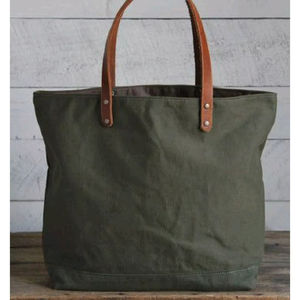 Sac fourre-tout en toile vert olive avec une texture robuste et solide et des poignées en cuir, conçu pour un transport quotidien durable sur l'épaule - Product Image 1
