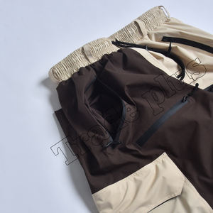Pantalons de neige bicolores marron et crème en gros, avec des poches cargo profondes à fermeture éclair, coupe décontractée et système de bas élastique - Product Image 3
