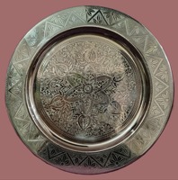 Assiette de service en fer finition argentée gravée avec motifs floraux et géométriques, design moderne pour les fêtes du Nouvel An
