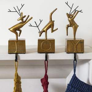 Heavy metal <b>stocking</b> <b>hanger</b> for fireplace mantels combining durable iron construction with festive seasonal details - Product Image 1