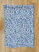 Tela de algodón puro premium con estampado floral índigo presenta elegantes patrones de ramas de flores azules bellamente estampados sobre un fondo blanco.