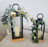 Pièce maîtresse de mariage élégante avec une combinaison d'arrangements floraux et de bougeoirs en métal antique pour la décoration