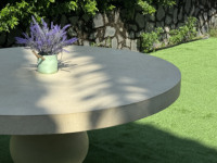 Table de salle à manger classique ronde en béton style grossiste, finition grès lisse, base sculpturale pour usage extérieur, villas