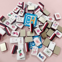 Tuiles de Mahjong de Noël populaires avec motifs rouges, verts, roses et dorés et icônes hivernales pour un ensemble de jeu de Mahjong décoratif de Noël