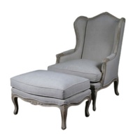 Fauteuil à bascule traditionnel avec repose-pieds, revêtu de tissu gris, structure en bois, accoudoirs courbes, dossier rigide, meubles de salon