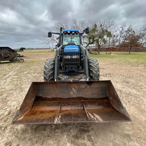 Tracteur HOL LAND TM125 d'occasion, modèle 1051, avec chargeur auto-nivelant 72LA, godet à fixation rapide de 96 pouces avec grappin - Product Image 1