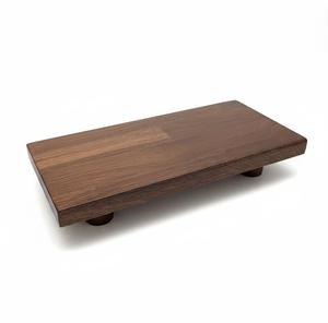Tabla de cortar rectangular de madera hecha a mano de diseñador con granos de madera oscura y patas cilíndricas - Product Image 1
