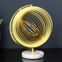 Sculpture décorative unique en forme ronde, en acier inoxydable avec base en marbre et boule en verre transparent, finition dorée antique