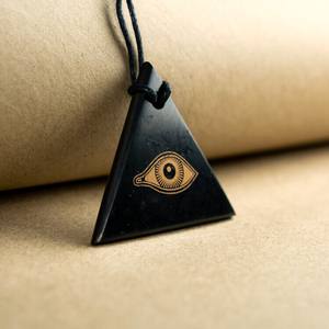 Colgante triangular de shungita pulido con serigrafía Ojo de Horus - Product Image 1
