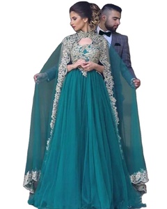 Magnifique femme en une robe longue en tulle vert sarcelle avec un complexe motif en dentelle dorée, col haut et dos cape. - Product Image 1