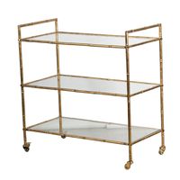 Chariot de service d'hôtel moderne en métal à trois niveaux, avec plateaux en verre transparent et roulettes pivotantes pour un déplacement fluide, idéal pour le salon