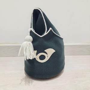 Ceci est un chapeau bicorne en feutre de laine vert foncé avec une bordure blanche et un pompon décoratif, doté d'un emblème de corne de cheval. - Product Image 5