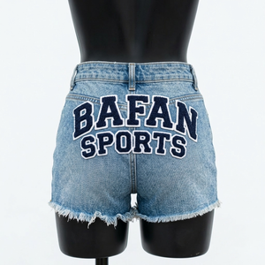 Shorts en jean pour femme 320 GSM en coton denim bleu clair, effet usé, ourlet brut, patch en chenille, logo personnalisé - Product Image 2