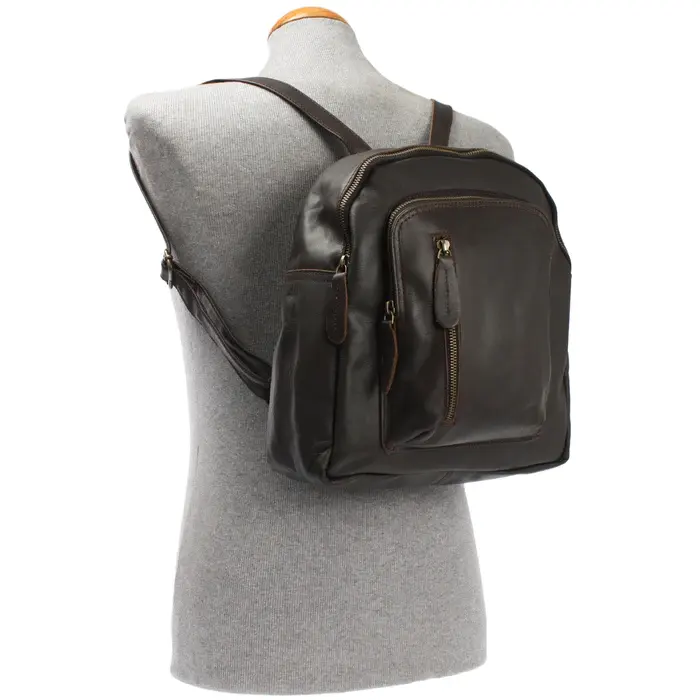 Mochila de couro em um sofisticado matiz marrom escuro, esta mochila moderna possui dois compartimentos com zíper na parte frontal