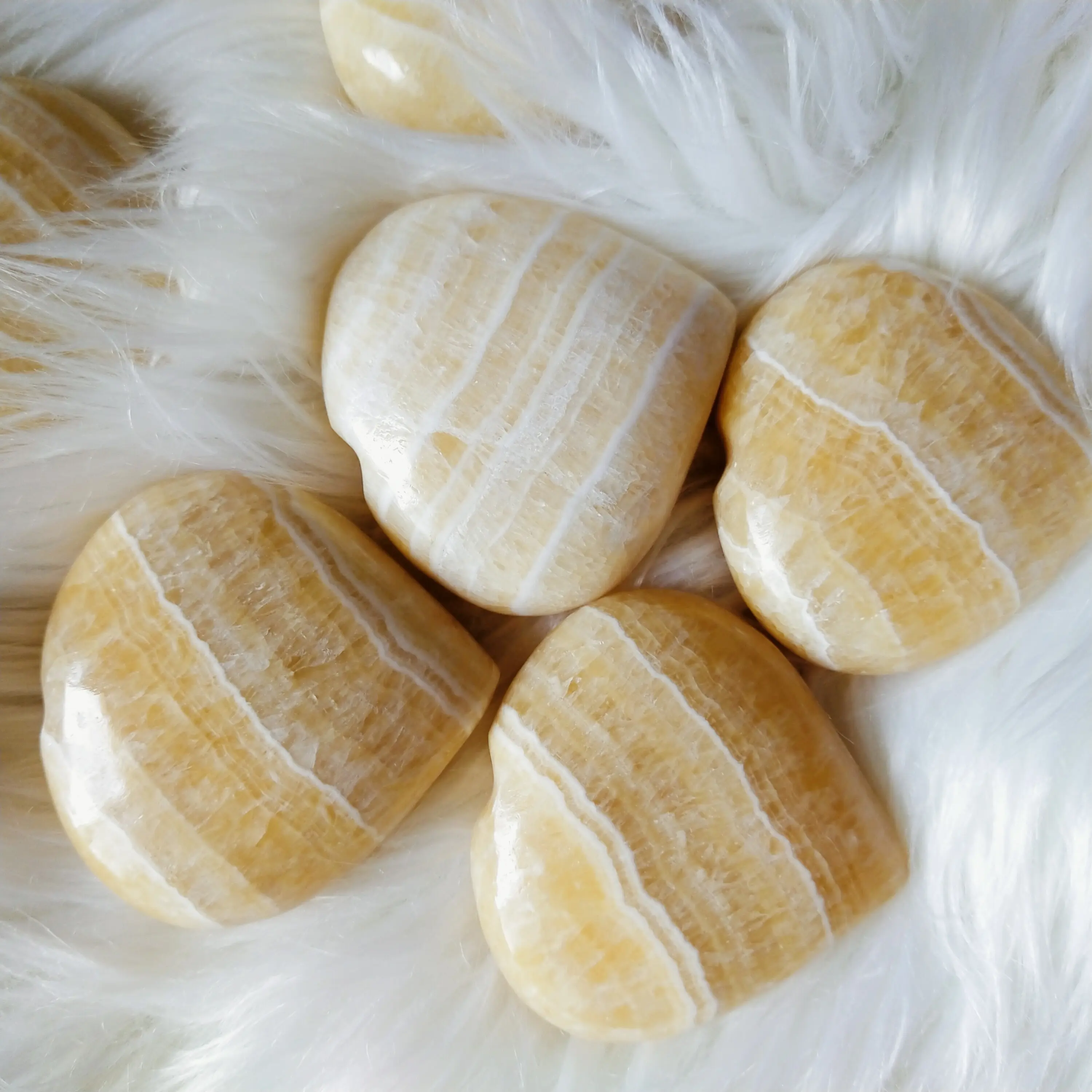 Großhandel Natural Yellow Calcite Heart Palm Stone wird häufig verwendet, um den Willen und das Selbstvertrauen zu verbessern und seinen Solar plexus