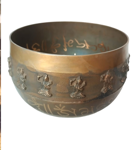 Un bol chantant tibétain avec des sculptures complexes de divinités et symboles sacrés autour de son extérieur. - Product Image 1