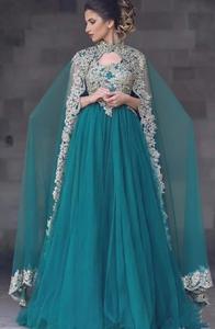 Magnifique femme en une robe longue en tulle vert sarcelle avec un complexe motif en dentelle dorée, col haut et dos cape. - Product Image 4