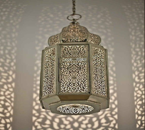 Una lámpara de mesa bellamente elaborada con metalistería detallada y una forma de cúpula que proyecta intrincados patrones de luz en toda la superficie - Product Image 3