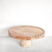 Support à gâteau artisanal en bois, avec des veines de bois prononcées et une surface polie, pour une esthétique rustique des centres de table de desserts.