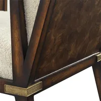 Fauteuil Boucle avec finitions en bois foncé et doré, pièce maîtresse idéale pour un coin lecture confortable.