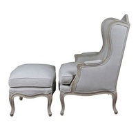 Fauteuil à bascule traditionnel avec repose-pieds, revêtu de tissu gris, structure en bois, accoudoirs courbes, dossier rigide, meubles de salon