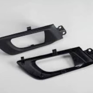 Componentes automotrices de primera calidad, específicamente manijas interiores de puertas o rejillas de parachoques, fabricados mediante moldeo por inyección de plástico. - Product Image 1
