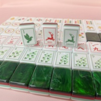 Ensemble de Mahjong de luxe vert émeraude avec dos marbré, côtés rayés et tuiles de jeu de Mahjong gravées avec des motifs botaniques