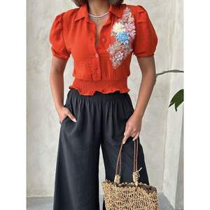 Chemisiers élégants en lin orange à motifs floraux sur la poitrine pour femmes Topshow, vente en gros - Product Image 2