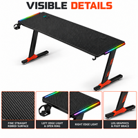 Bureau de jeu noir avec plateau rectangulaire côtelé et pieds orange pour bureaux à domicile, salles d'étude et salles de jeu
