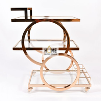 Chariots de service de luxe en verre propre et métal décoré avec une bordure dorée pour le dîner et le déjeuner