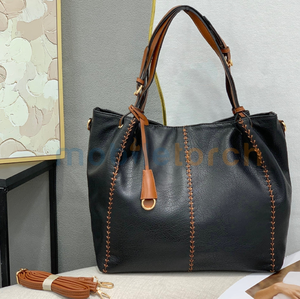 Un sac cabas en cuir noir avec des poignées marron contrastées et des coutures de selle uniques sur le devant - Product Image 1