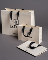 Hediye paketleme için kolu halat ile lüks özel Logo kabartmalı baskılı giyim karton perakende kağıt alışveriş torbaları