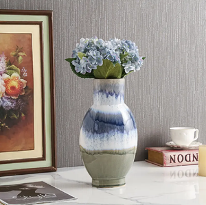 Un conjunto de cuatro jarrones de cerámica coloridos y de forma única, con tres en posición vertical, dispuestos en una pila de libros antiguos. - Product Image 2