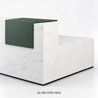 Bureau de réception en L en bois aspect marbre blanc avec accent vert foncé et façade grise côtelée pour projets de hall d'accueil de bureau moderne