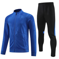Survêtement sportif pour homme, bleu, noir et blanc, avec blocs de couleur, col roulé zippé, poches latérales, idéal pour l'automne